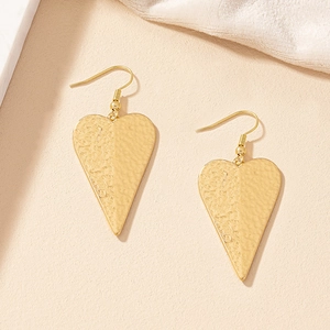 Detail of gold heart drop earrings with handcrafted hammered texture and hook design