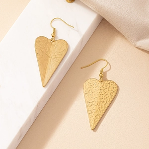 Golden heart drop earrings with hammered metal texture and radiant engraved finish
