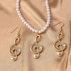 Détail du collier de perles note de musique et boucles d'oreilles clé de sol