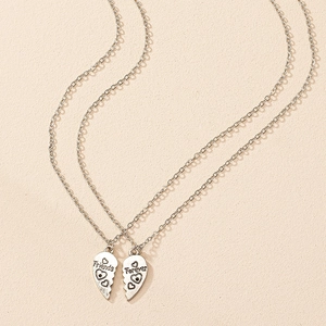 Close-up of Friends Forever heart-shaped puzzle necklaces with silver finish engravings