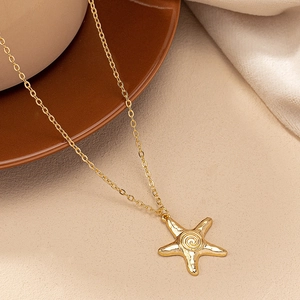 Détail du pendentif étoile de mer dorée avec design en spirale sur une chaîne en O