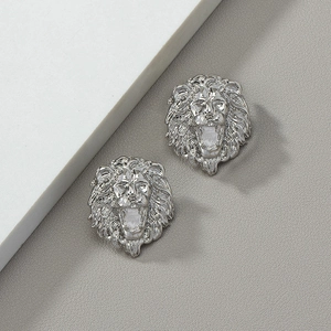 Silver lion head stud earrings with detailed 3D texture on minimalist grey background