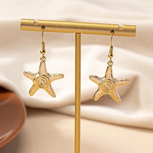 Boucles d'oreilles bohèmes en forme d'étoile de mer dorée sur un support élégant