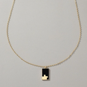 Detail of a vintage black checkered rectangle pendant necklace with gold metal chain