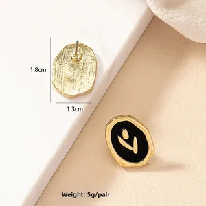 Vue détaillée des boucles d'oreilles rose en émail avec finition dorée géométrique
