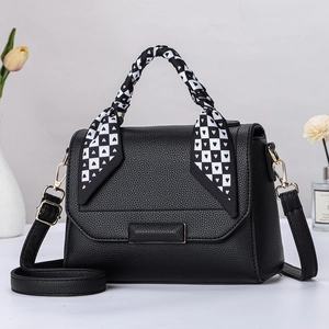 Elegante schwarze Handtasche aus Leder mit gemustertem Seidenschal am oberen Griff