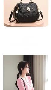 Detail of black quilted shell-shaped shoulder bag with golden clover lock and stitching