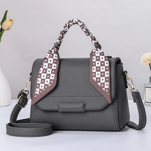Detail einer grauen Handtasche aus Litschi-Leder mit seidenem Griff und Karomuster