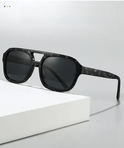 Close-up of textured black aviator sunglasses with double bridge on a white display