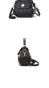 Detail view of black quilted shell-shaped shoulder bag with golden clover metal buckle