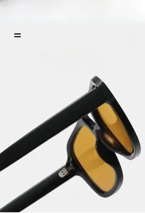 Detail of metal hinge on black pilot sunglasses with amber lenses and elastic frame