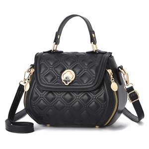 Black quilted shell shoulder bag with golden petal lock and leather top handle