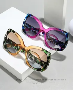 Detalle de gafas de sol de mariposa bicolor con montura estampada y lentes de degradado