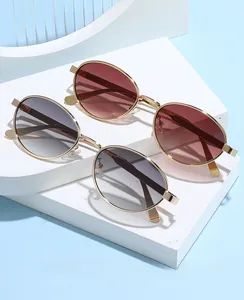 Close-up of retro oval metal sunglasses with gold frames on a modern minimalist display