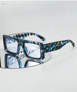 Detail of dark blue tortoise shell texture on thick square glasses frame over mirror