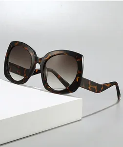 Detalle de gafas de sol de carey oversize con patillas onduladas y lentes degradadas
