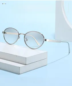 Detailed view of silver oval metal frame sunglasses with light blue gradient lenses