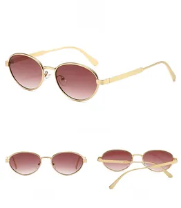 Detail view of oval vintage sunglasses with gold metal frame and gradient lenses