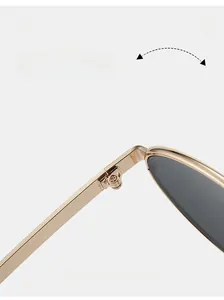 Macro close-up of a durable golden metal hinge and grey lens on vintage oval sunglasses