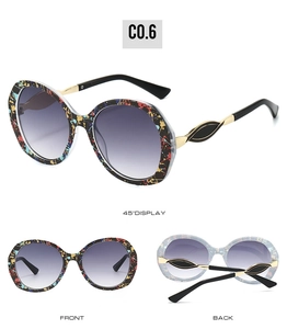 Detail view of large frame glasses featuring artistic paint texture and gold leaf accents
