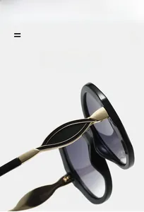 Close-up of golden hollow metal hinges on sleek black oversized fashion glasses