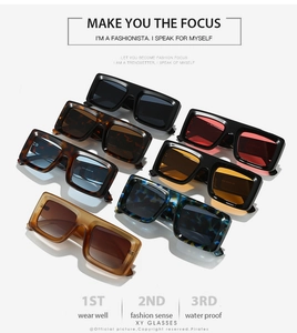 Flat lay of wide frame rectangle sunglasses in seven assorted jelly colors and tints