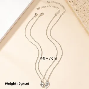 Detail of Mother Daughter heart pendant necklaces with engraved text and 40+7cm chain length