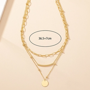 Three-layer gold necklace with rectangular links, round beads and a circular pendant