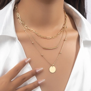 Three-layer gold necklace with disc pendants and beads on a fashion model