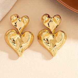 Golden heart-shaped drop earrings with a layered irregular hammered metal texture