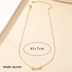 Detail of gold LOVE pendant necklace with adjustable chain on textured background