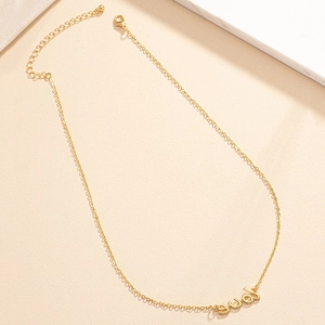 Elegant gold-tone LOVE letter pendant necklace with adjustable chain on marble surface