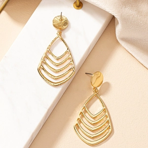 Elegant gold hollow teardrop earrings with multi-layered geometric lines on white marble