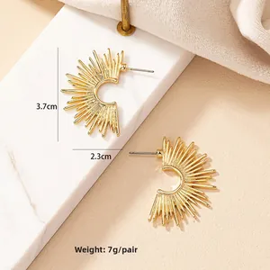 Detailed close-up of gold semi-circle sunburst earrings on a marble surface, size 3.7x2.3cm