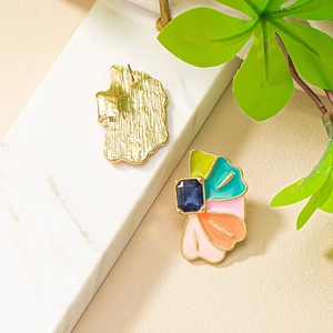 Boucles d'oreilles fleurs en émail coloré avec pierre bleue sur marbre