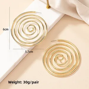 Detailed view of oversized gold spiral hoop earrings with 6cm x 5.7cm size specs