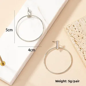 Detail view of silver hoop earrings showing a 4cm diameter and 5g weight on a marble stand