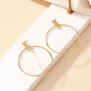 Minimalist gold oversized hoop earrings with sleek rectangular bar accent on marble