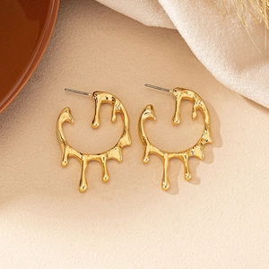 Detailed macro shot showing the molten liquid metal texture of gold water drop earrings