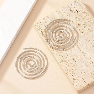 Modern silver spiral hoop earrings with minimalist geometric design on marble surface