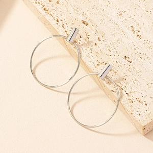 Minimalist silver geometric earrings featuring slim hoops and rectangular studs on stone