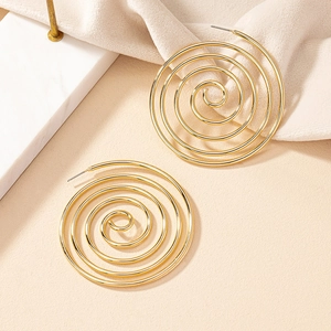 Macro detail of golden spiral hoop earrings with polished finish and layered circles