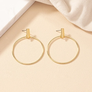 Detailed view of elegant gold minimalist large hoop earrings on a textured backdrop