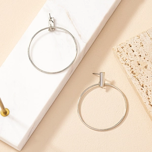 Minimalist silver geometric hoop earrings with polished rectangular studs on marble