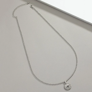 Macro shot of silver Evil Eye pendant with radial textures and adjustable chain links