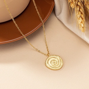 Elegant gold round spiral disc pendant necklace on minimalist beige background