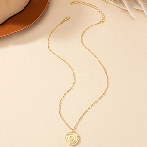 Minimalist gold disc pendant necklace with spiral texture and adjustable chain detail