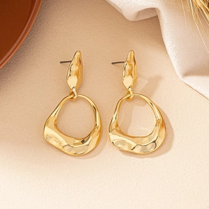 Detailed macro shot of gold irregular geometric earrings with textured lava finish