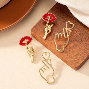 Fashion heart and red lip earrings set on textured display background