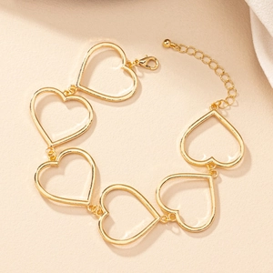 Detailansicht eines goldenen Armbandes mit hohlen Herzgliedern und Karabinerverschluss